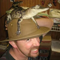 A man with an alligator on his head